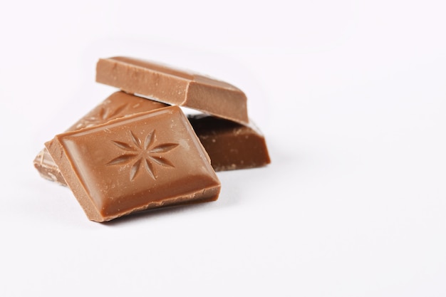 Ciérrese encima de una barra de chocolate aislada en el fondo blanco.