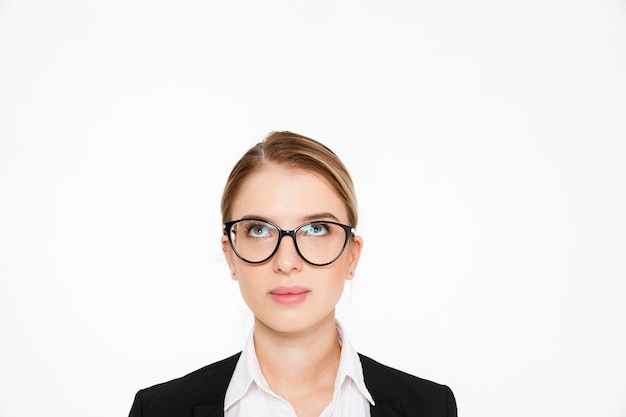 Ciérrese encima de la imagen de la mujer de negocios rubia despreocupada en lentes que mira para arriba sobre blanco