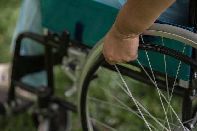 Foto gratuita ciérrese encima de la mujer mayor sola que se sienta en la silla de ruedas en el jardín en hospital