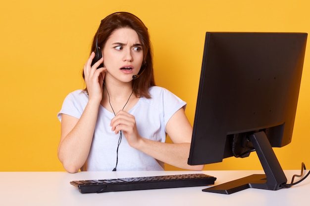 Ciérrese encima del retrato de la chica joven hermosa con los auriculares, poses en el amarillo