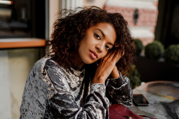 Ciérrese encima del retrato del estilo de vida de la mujer negra pensativa que disfruta del descanso para tomar café en París.