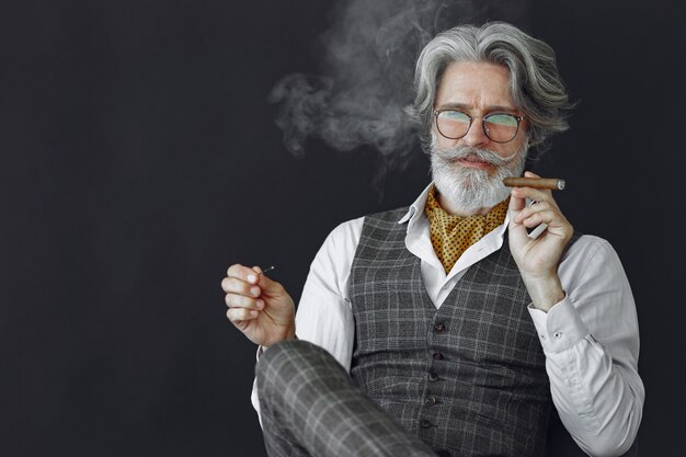 Ciérrese encima del retrato del hombre pasado de moda sonriente. Abuelo con un puro y whisky.