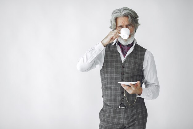 Ciérrese encima del retrato del hombre pasado de moda sonriente. Abuelo con una taza de té.