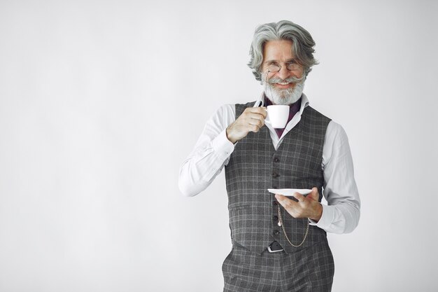 Ciérrese encima del retrato del hombre pasado de moda sonriente. Abuelo con una taza de té.