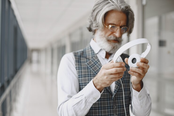 Foto gratuito ciérrese encima del retrato del hombre pasado de moda sonriente. hombre elegante en la oficina. senior con auriculares.