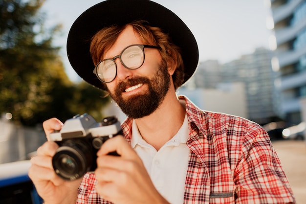 Foto gratuita ciérrese encima del retrato del hombre sonriente de la barba del inconformista que usa la cámara de película retra