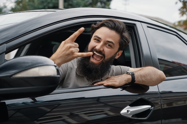 Ciérrese encima del retrato lateral del hombre feliz que conduce el coche