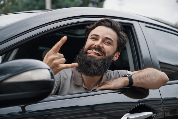 Ciérrese encima del retrato lateral del hombre feliz que conduce el coche