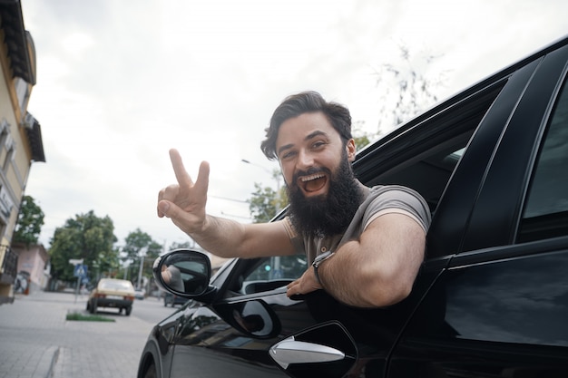 Foto gratuita ciérrese encima del retrato lateral del hombre feliz que conduce el coche