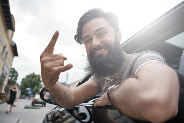 Ciérrese encima del retrato lateral del hombre feliz que conduce el coche