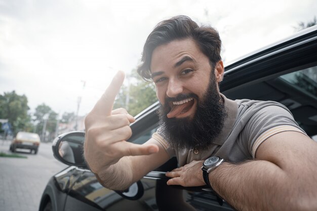 Ciérrese encima del retrato lateral del hombre feliz que conduce el coche