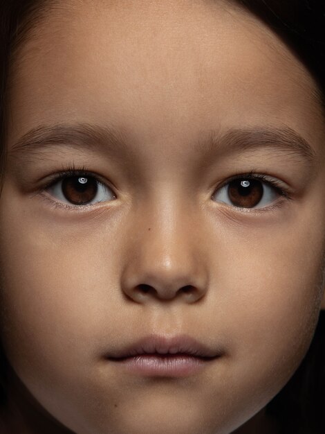 Ciérrese encima del retrato de la muchacha asiática pequeña y emocional. Photoshot muy detallado de modelo femenino con piel bien cuidada y expresión facial brillante. Concepto de emociones humanas. Mirando a la cámara.