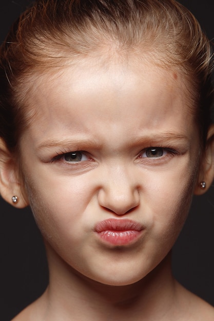 Ciérrese encima del retrato de la muchacha caucásica pequeña y emocional. Photoshot muy detallado de modelo femenino con piel bien cuidada y expresión facial brillante. Concepto de emociones humanas. Asqueroso.