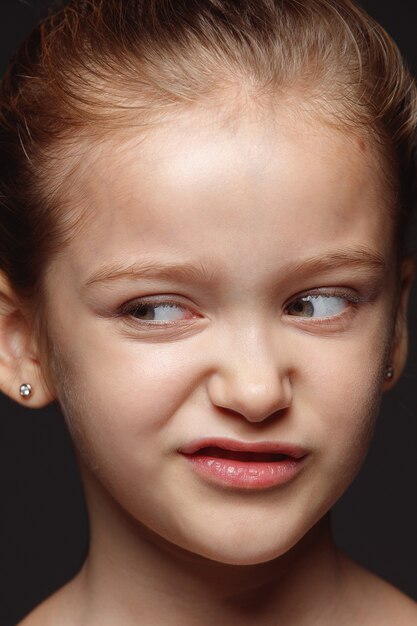 Ciérrese encima del retrato de la muchacha caucásica pequeña y emocional. Sesión de fotos muy detallada de modelo femenino con piel bien cuidada y expresión facial brillante. Concepto de emociones humanas. Repugnante.