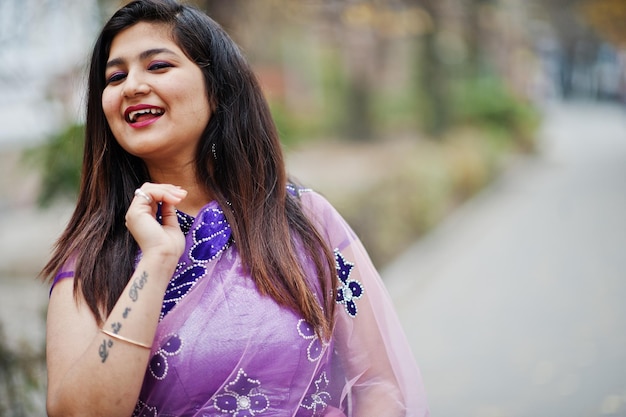 Ciérrese encima del retrato de la muchacha hindú india en el sari violeta tradicional que se presenta en la calle