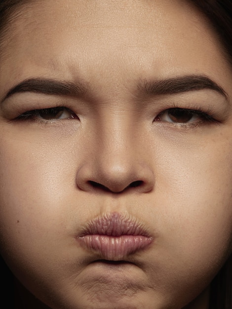 Foto gratuita ciérrese encima del retrato de la mujer china joven y emocional. photoshot muy detallado de modelo femenino con piel bien cuidada y expresión facial brillante. concepto de emociones humanas. enojado, soplido, distendido.