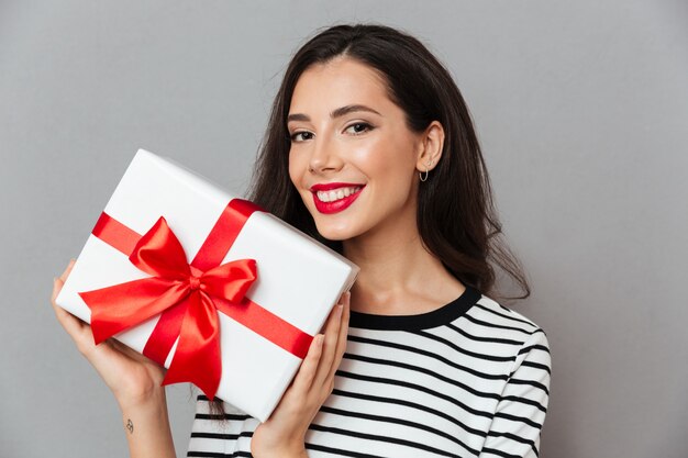 Ciérrese encima del retrato de una mujer feliz que sostiene la caja de regalo