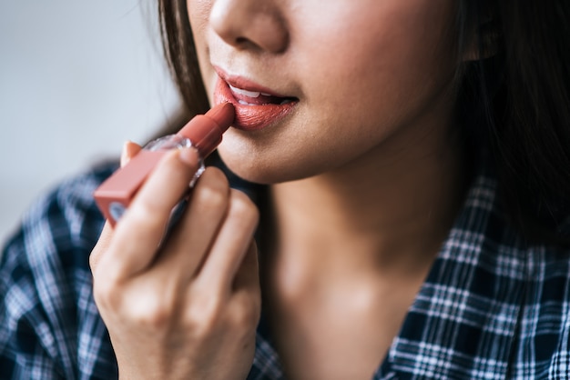 Ciérrese encima del retrato de la mujer que toca sus labios con el lápiz labial.