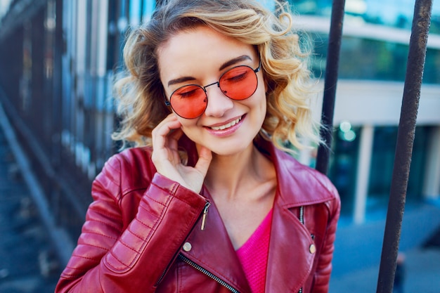 Ciérrese encima del retrato positivo de la mujer feliz alegre en jersey rosado