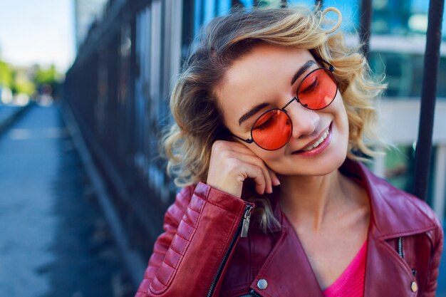 Ciérrese encima del retrato positivo de la mujer feliz alegre en jersey rosado