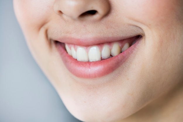 Foto gratuita ciérrese encima del retrato de la sonrisa asiática joven de los dientes de la muchacha