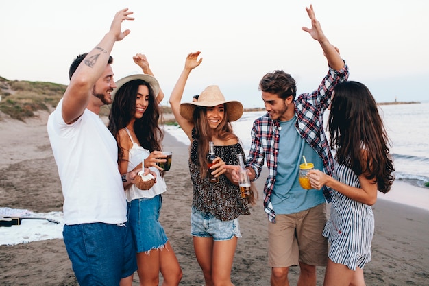 Cinco amigos celebrando en la playa