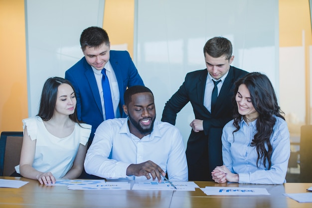 Foto gratuita cinco compañeros de trabajo en un escritorio