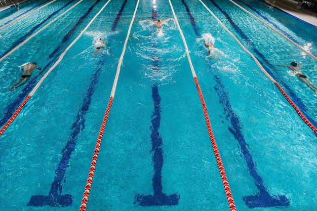 Cinco nadadores corriendo uno contra el otro en una piscina