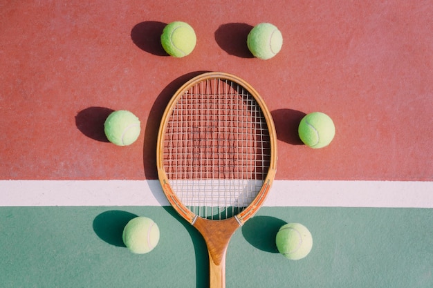 Foto gratuita cinco pelotas de tenis y raqueta en simetría