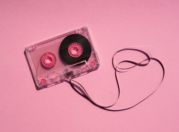 Cinta de cassette rota transparente sobre fondo rosa