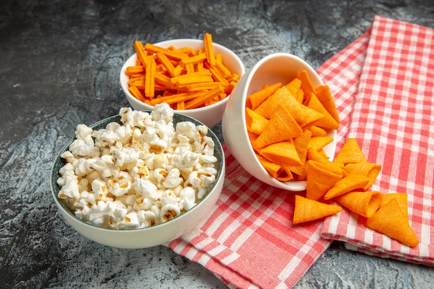 Cips de queso vista frontal con bizcochos y palomitas de maíz en el fondo claro