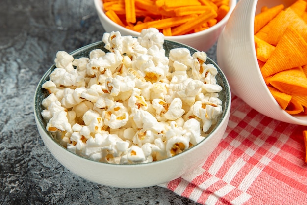 Cips de queso vista frontal con bizcochos y palomitas de maíz en el fondo claro