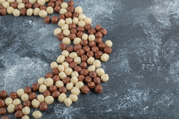 Foto gratuita círculo de copos de bolas de maíz de chocolate en gris.