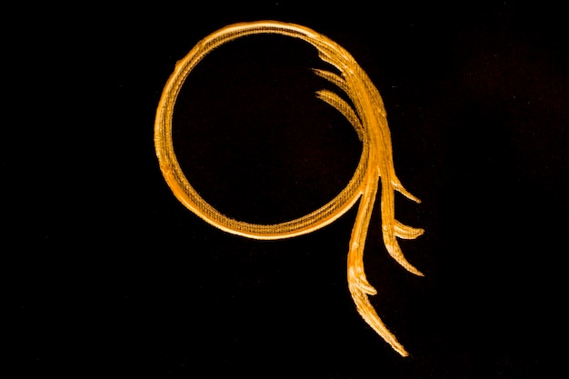 Círculo dorado pintado sobre fondo negro
