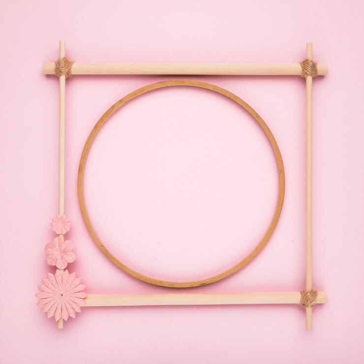 Foto gratuito círculo de madera dentro del marco cuadrado sobre fondo rosa