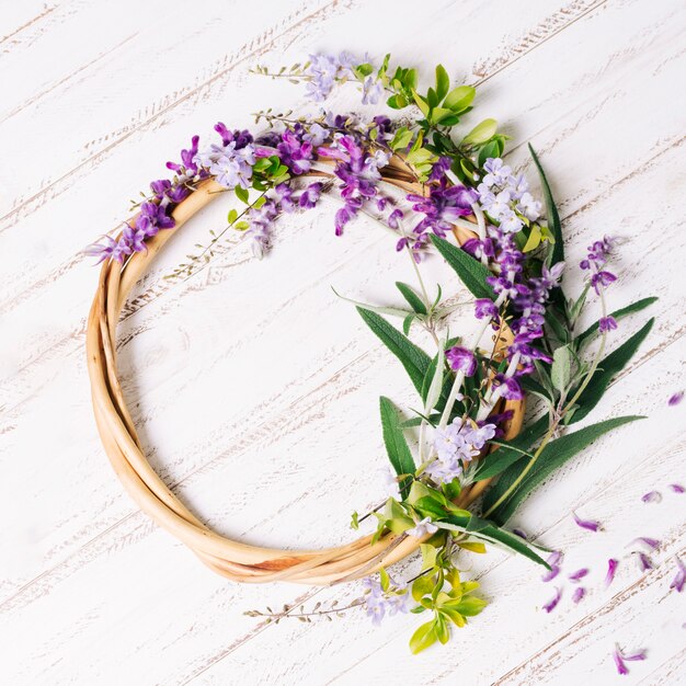 Círculo de madera con flores y hojas.