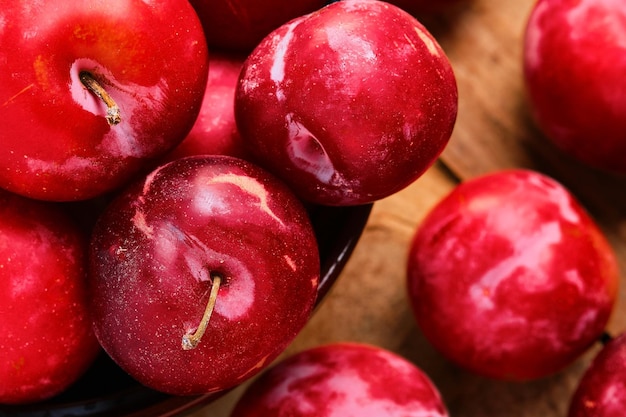 Ciruelas rojas en una taza de ciruelas frescas del mercado de un agricultor primer plano enfoque selectivo Cosecha de verano la idea de hacer pasteles dulces