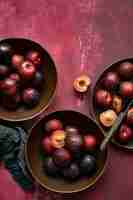 Foto gratuita ciruelas rojas en un tazón flatlay de comida de verano