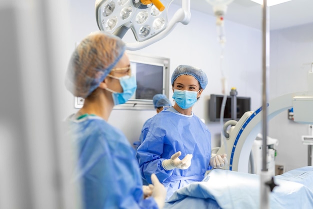 Cirujana con mascarilla quirúrgica en el quirófano Joven doctora en uniforme quirúrgico en el quirófano del hospital