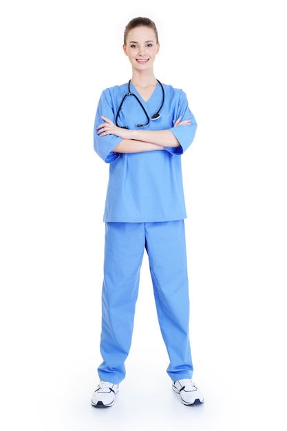 Foto gratuita cirujano femenino acertado atractivo joven que se coloca en uniforme azul