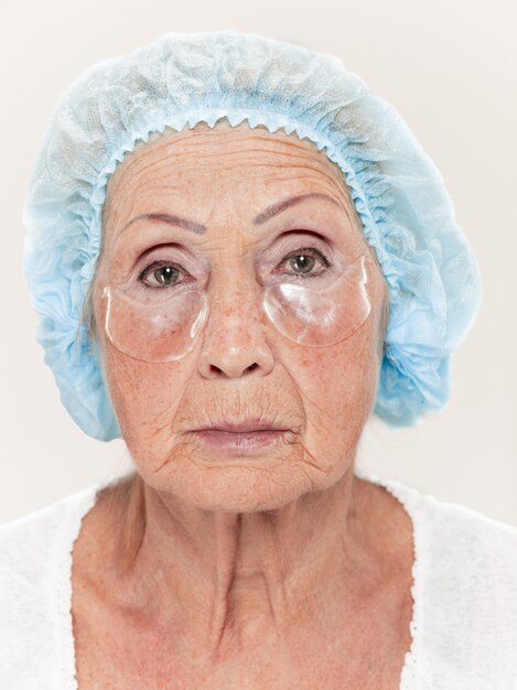 Cirujano haciendo un control de la piel de una mujer de mediana edad antes de la cirugía plástica