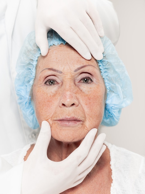 Foto gratuita cirujano haciendo un control de la piel de una mujer de mediana edad antes de la cirugía plástica