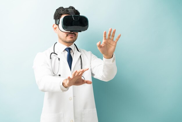 Cirujano médico con gafas de realidad virtual gesticulando contra el fondo de color