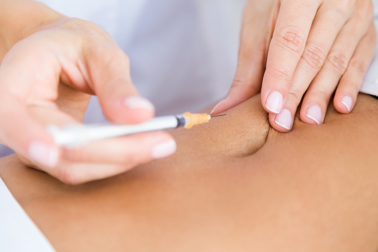 Foto gratuito cirujano que hace la inyección en el cuerpo femenino. concepto de liposucción