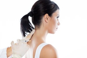 Foto gratuita cirujano que hace la inyección en el cuerpo femenino. concepto de terapia neuronal.