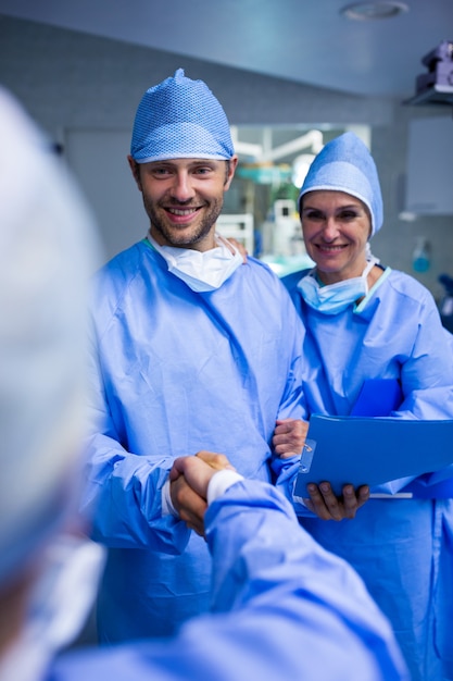 Cirujanos de agitar la mano en la sala de operación