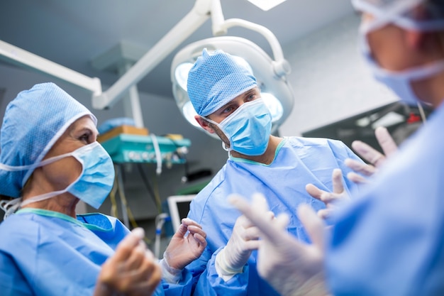 Los cirujanos que interactúan entre sí en la sala de operación