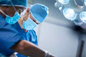 Foto gratuita los cirujanos que realizan la operación en la sala de operación