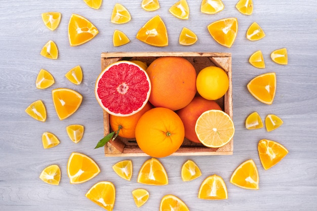 Los cítricos en la caja de madera rodeada de naranjas