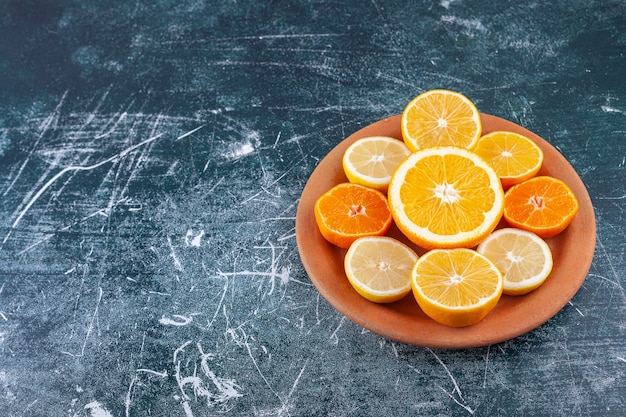 Foto gratuita cítricos frescos picados colocados en un plato redondo de arcilla.